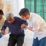 An elderly man receiving assistance from caregivers in a cozy home environment., tags: hüftfrakturen und - pexel